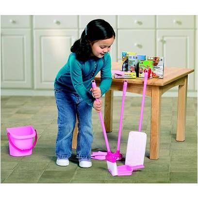 Une petite fille est occupée à nettoyer le sol de ce qui semble être une cuisine. Tous les ustensiles , balai, pelle à poussière, seau... sont roses.